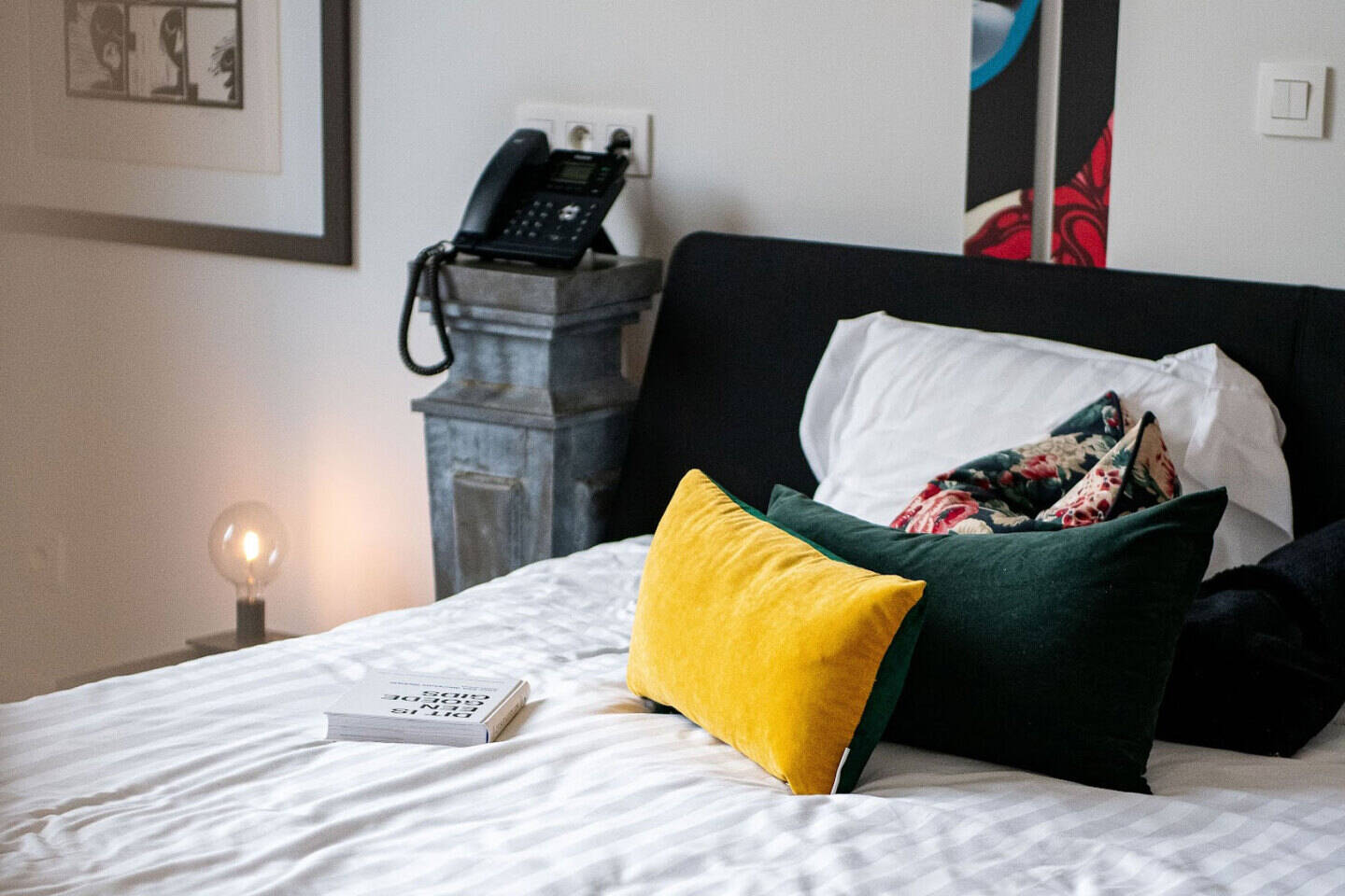 Atmospheric bed with cushions and artistic accents in the Giulia room